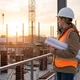 Bauleiterin blickt über eine Baustelle